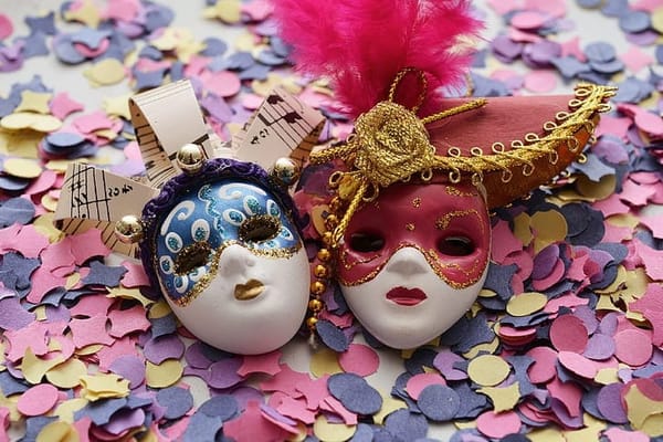 Two traditional-style doll masks, one in red, one in blue
